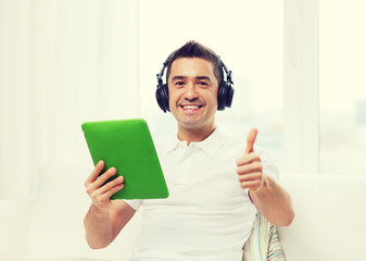 Poster - smiling man with tablet pc and headphones at home