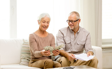 Canvas Print - senior couple with money and calculator at home