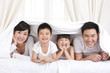 © Blue Jean Images - Happy family lying in bed