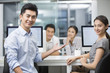 © Blue Jean Images - Portrait of young businessman and businesswoman in office