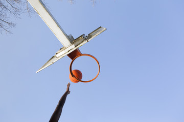 Wall Mural - Basketball player jumping to dunk against blue sky