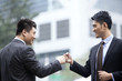 © Blue Jean Images - Excited businessmen celebrating and doing fist bump, Hong Kong