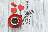 Fototapeta Mapy - Red cup with coffee beans  and red hearts on wooden background 