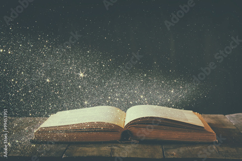 abstract image of open antique book on wooden table Poster