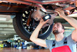 Mechaniker kontrolliert Abgasanlage eines Autos in der Werkstatt // Mechanic controlled exhaust of a car in the garage