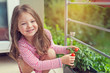 © Myst - cute little girl holding growing tomatoes in pot