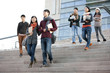 © Blue Jean Images - Young college students walking down steps of university building
