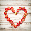 Red apples heart wooden background. Love concept vintage