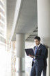 © Blue Jean Images - Young businessman using laptop in airport