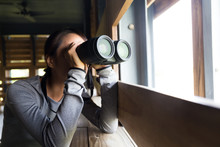 Young Woman Use Of The Binoculars At Indoor