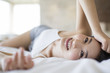 © Blue Jean Images - Portrait of smiling young woman lying on bed
