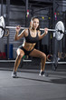 Young woman lifting barbell at gym