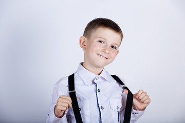 Wall Mural - Smiling little boy holding his braces.Happy little boy over white background.Smiling, Happy, Joyful beautiful little boy , looking at camera.