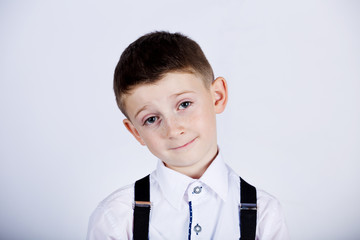 Wall Mural - Funny emotion of  little boy young man with a raised eyebrow wearing costume with braces.Happy little boy over white background.Smiling, Happy, Joyful beautiful little boy , looking at camera.