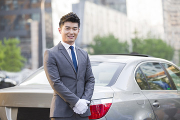 Portrait of chauffeur standing next to the car