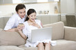 © Blue Jean Images - Young couple using a laptop at home