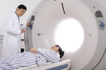  Medical professional helping a patient into a MRI scanner