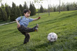Young Boy Happily Playing Soccer In The Park