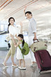 © Blue Jean Images - Happy family at the airport waving goodbye