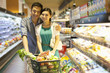 © Blue Jean Images - Young couple shopping in supermarket