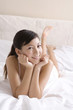 © Blue Jean Images - Asian woman on bed