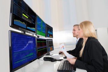 Business People Analyzing Data Displayed On Computer Screens