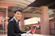 © Blue Jean Images - Portrait of smiling businessman using a laptop at station