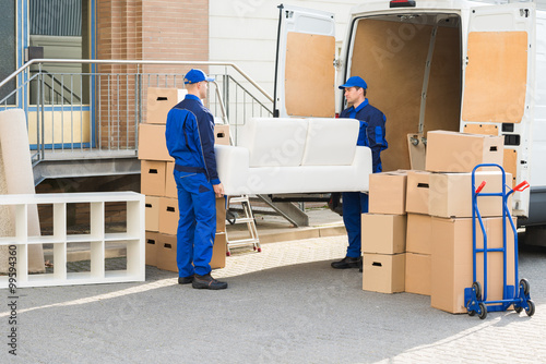Fotografía Movers Carrying Sofa Outside Truck On Street