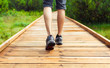 © kieferpix - closeup of male walking through wooden path in the forest.