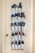 Various Athletic Shoes On Pockets Of Door Organizer