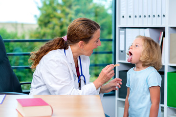 female pediatrician in white lab coat examined little patient