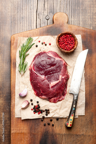 Raw ribeye steak on a cutting board, top view Poster