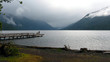 Crescent Lake - A fisherman stands at the end of a dock as clouds descend from the mountains around Crescent Lake in Olympic National Park.