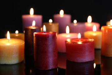 Wall Mural - Many burning small candles on dark background, close-up