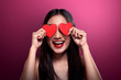 Beautiful asian girl holding red heart cover her eyes