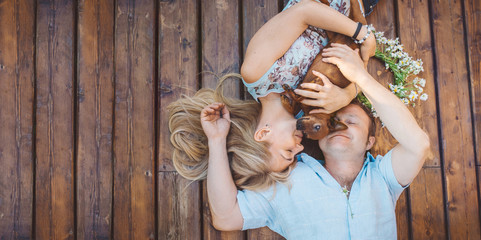 Man and woman lying on a terrace with their dog.