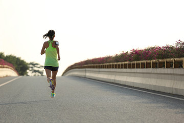 Canvas Print - young woman runner running on city bridge road