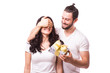 © F8  \ Suport Ukraine - Man keeps his girlfriend eyes covered while she giving a gift , romantic surprise for Valentine Day. Man look at woman. Caucasian couple. White background.