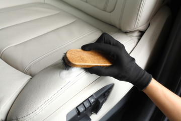 Car service. Worker washing of interior by a brush