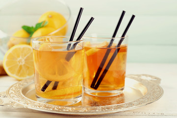 Wall Mural - Iced tea with lemon on light wooden background