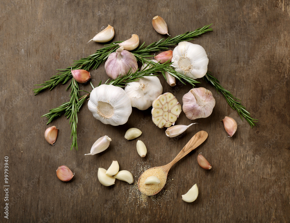 Composition of garlic and rosemary on wooden background