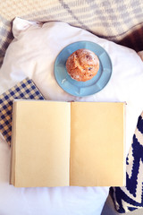 Sticker - Open book, plaid and coffee on sofa. Top view