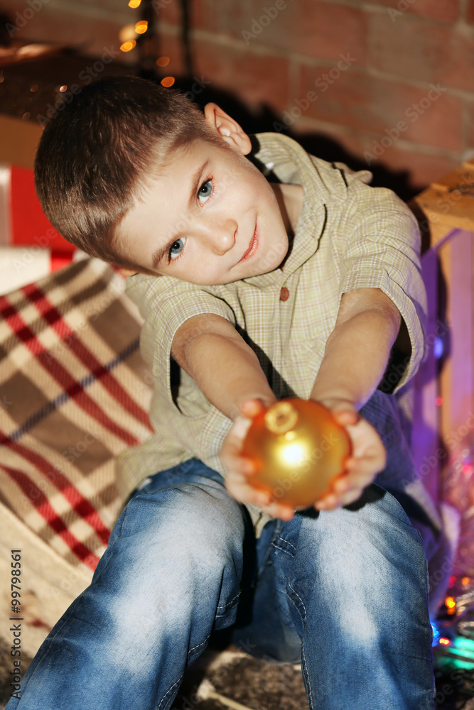 Little boy with yellow bauble at home