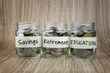 Coins in glass jar with saving, retirement and education label. Financial Concept