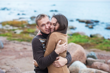 Wall Mural - Loving couple hugging on the rocky beach