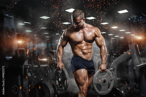 Fotografía Muscular athletic bodybuilder fitness model posing after exercises in gym