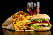 Big Cheeseburger With Glass Of Cola And French Fries On Black Desk