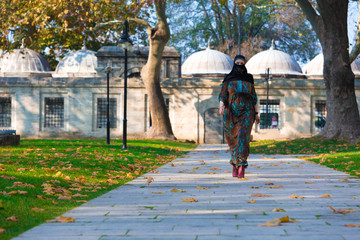 Wall Mural - Young Muslim Woman walking in park