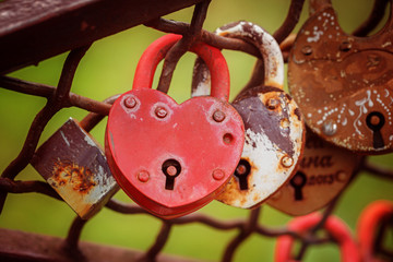 Love red heart-shaped padlock locked on iron chain