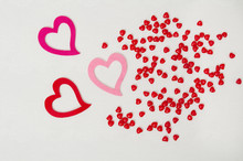 Three Pink And Red Valentine Hearts On A Rough Painters Canvas Background With Cinnamon Heart Candy